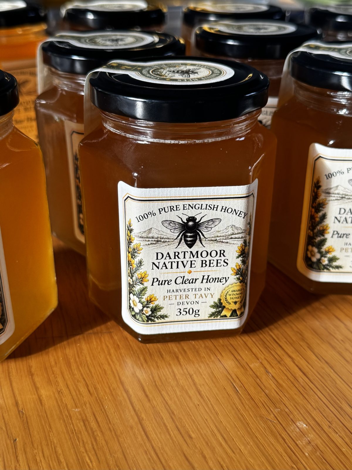 Hand-filled jars of Pure Clear Honey lined up after labelling